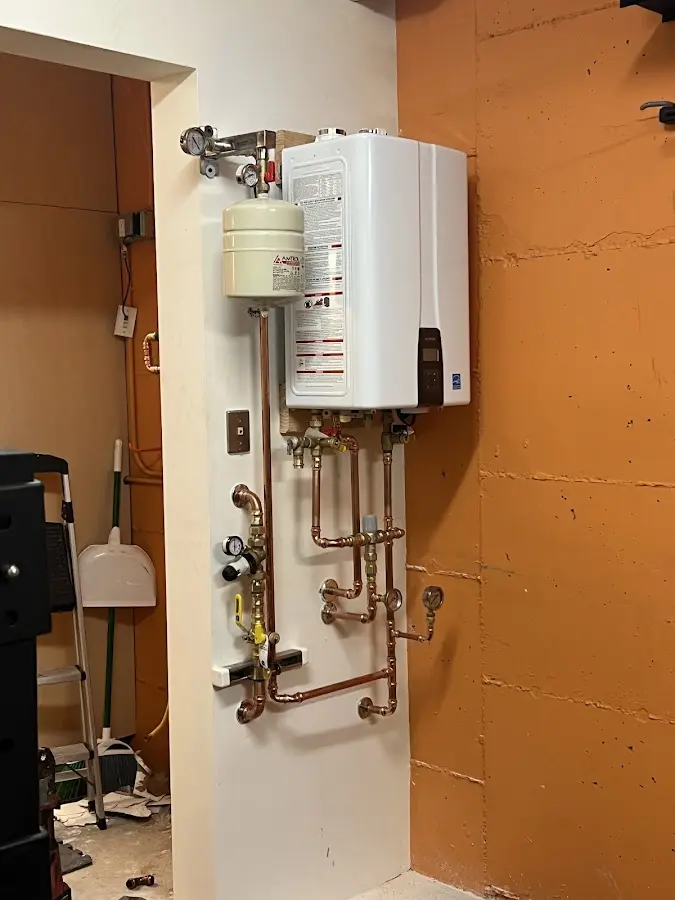 Plumbing technician inspecting water heater connections in Swainsboro